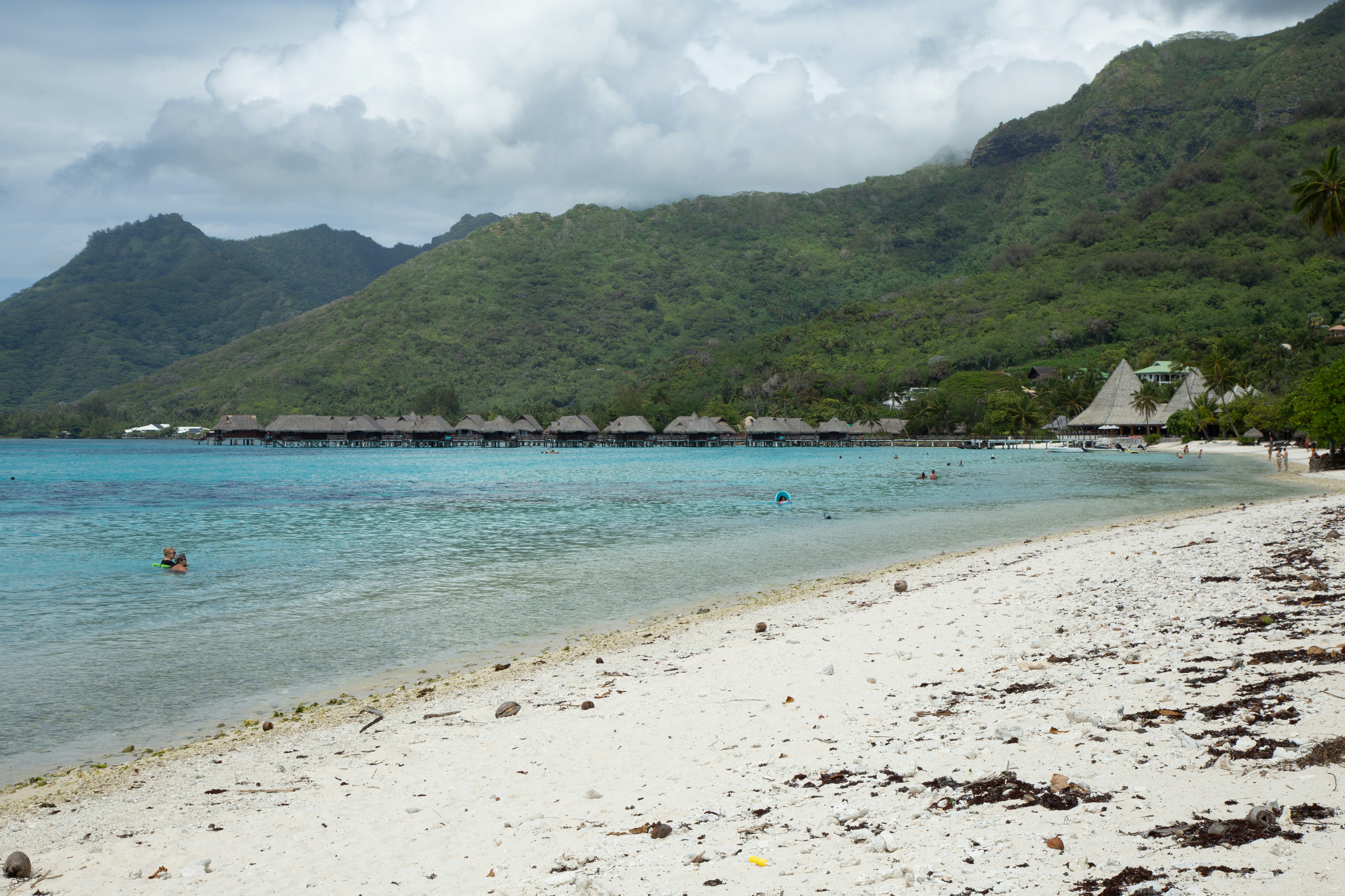 Beautiful beach with bungalows and mountains.