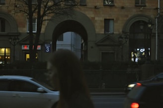Building with arches and street at dusk.