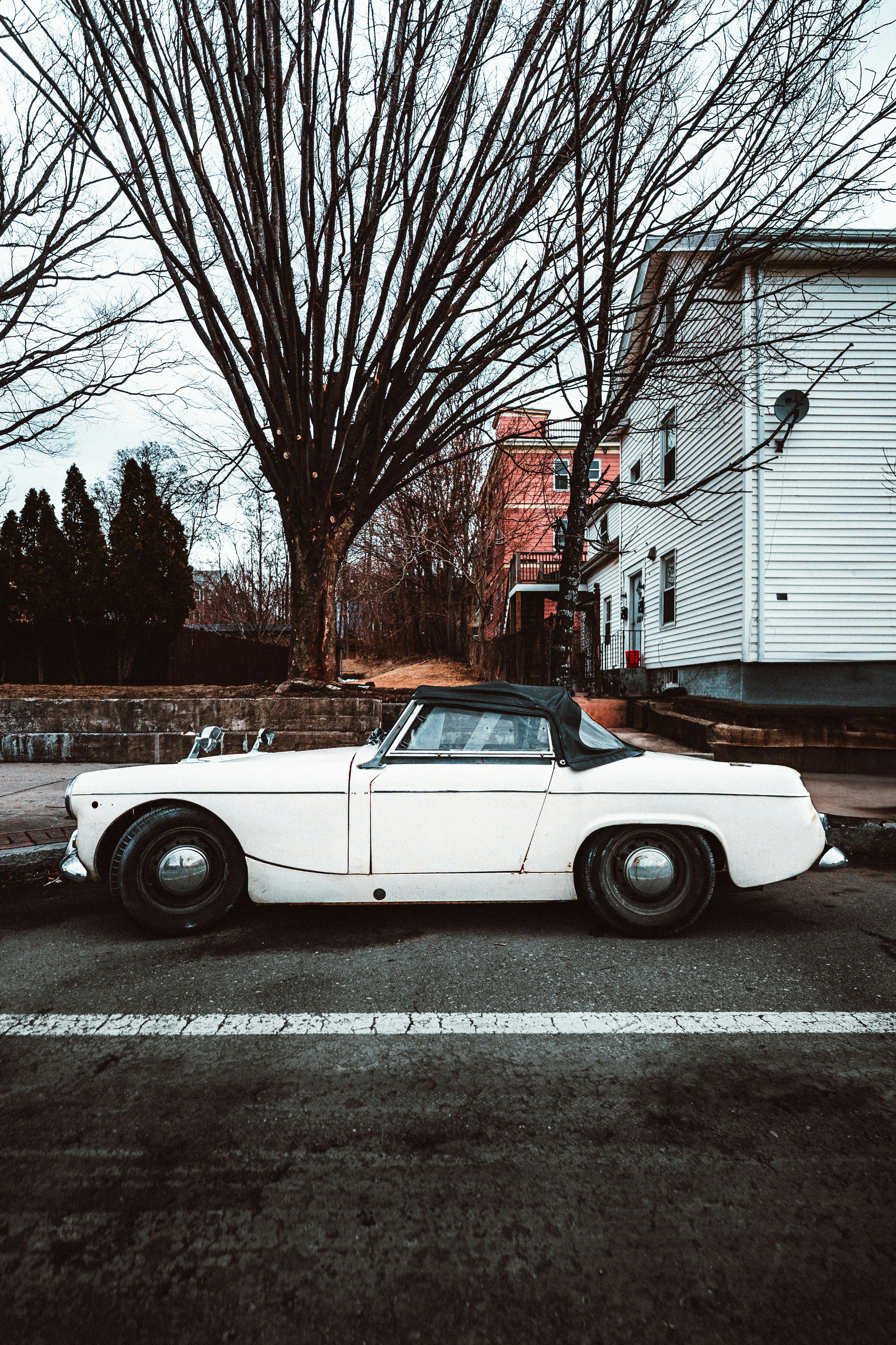 Classic white car parked on a city street.