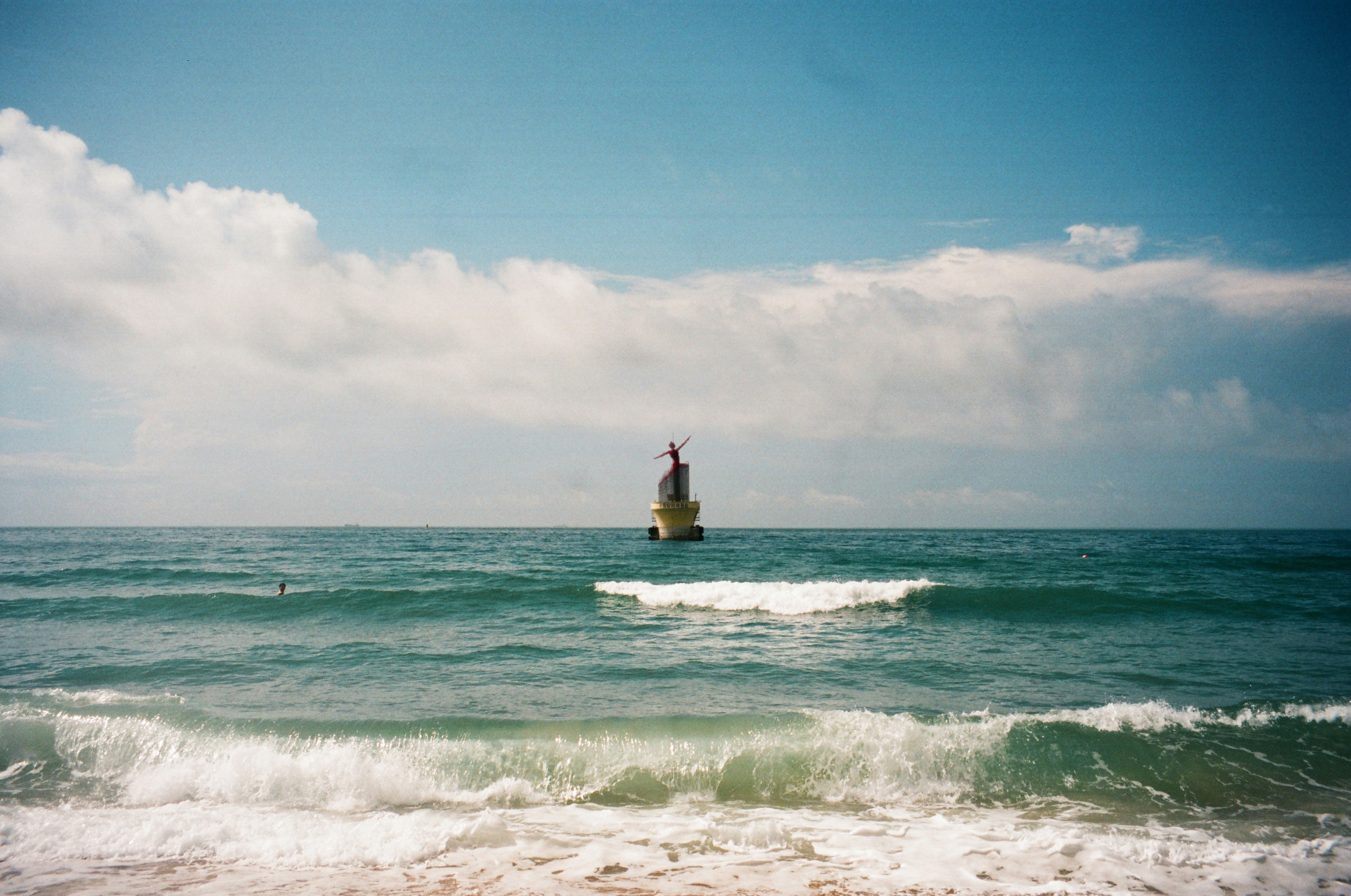 Lighthouse stands alone in the vast ocean.