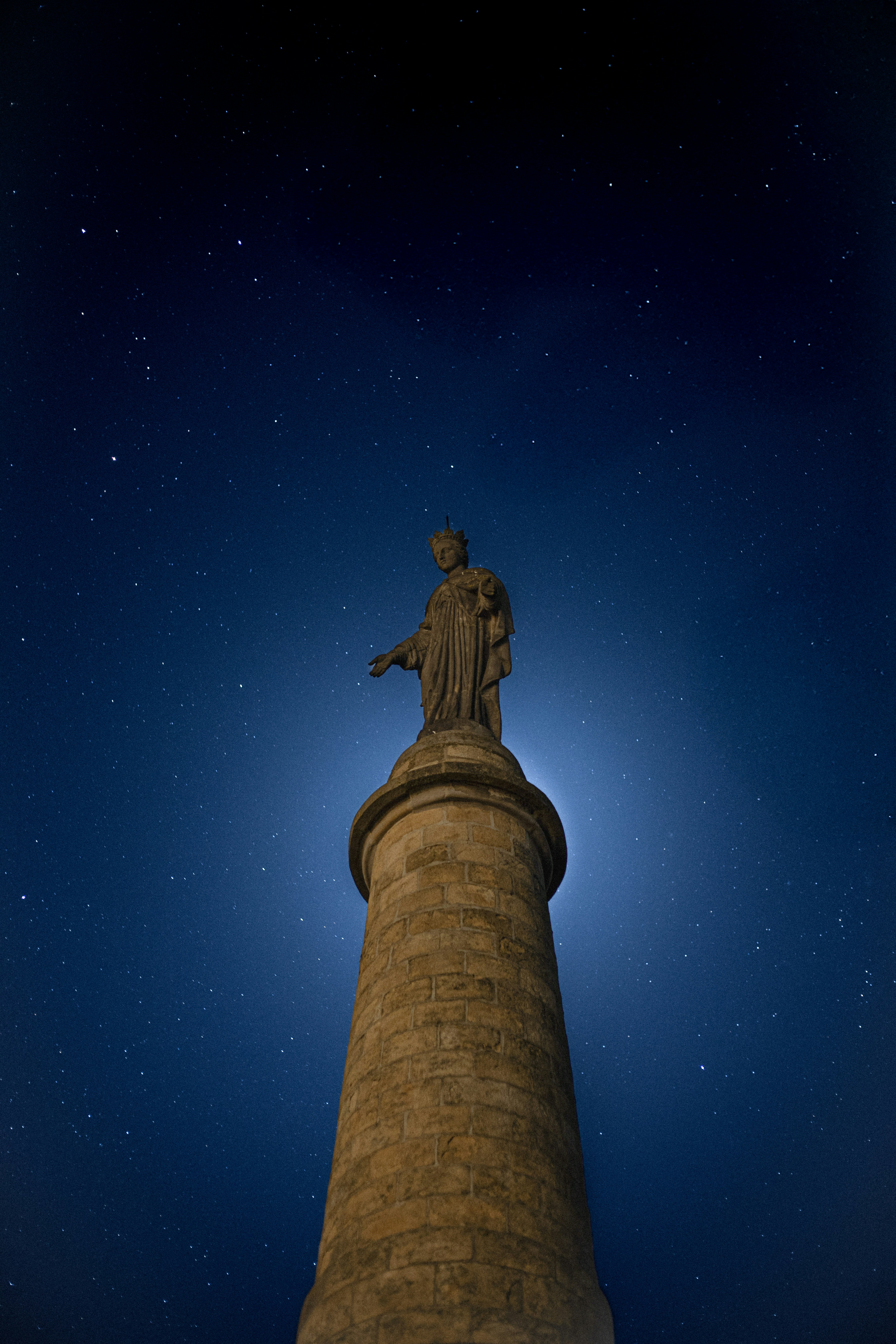 Statue against a starry night sky.