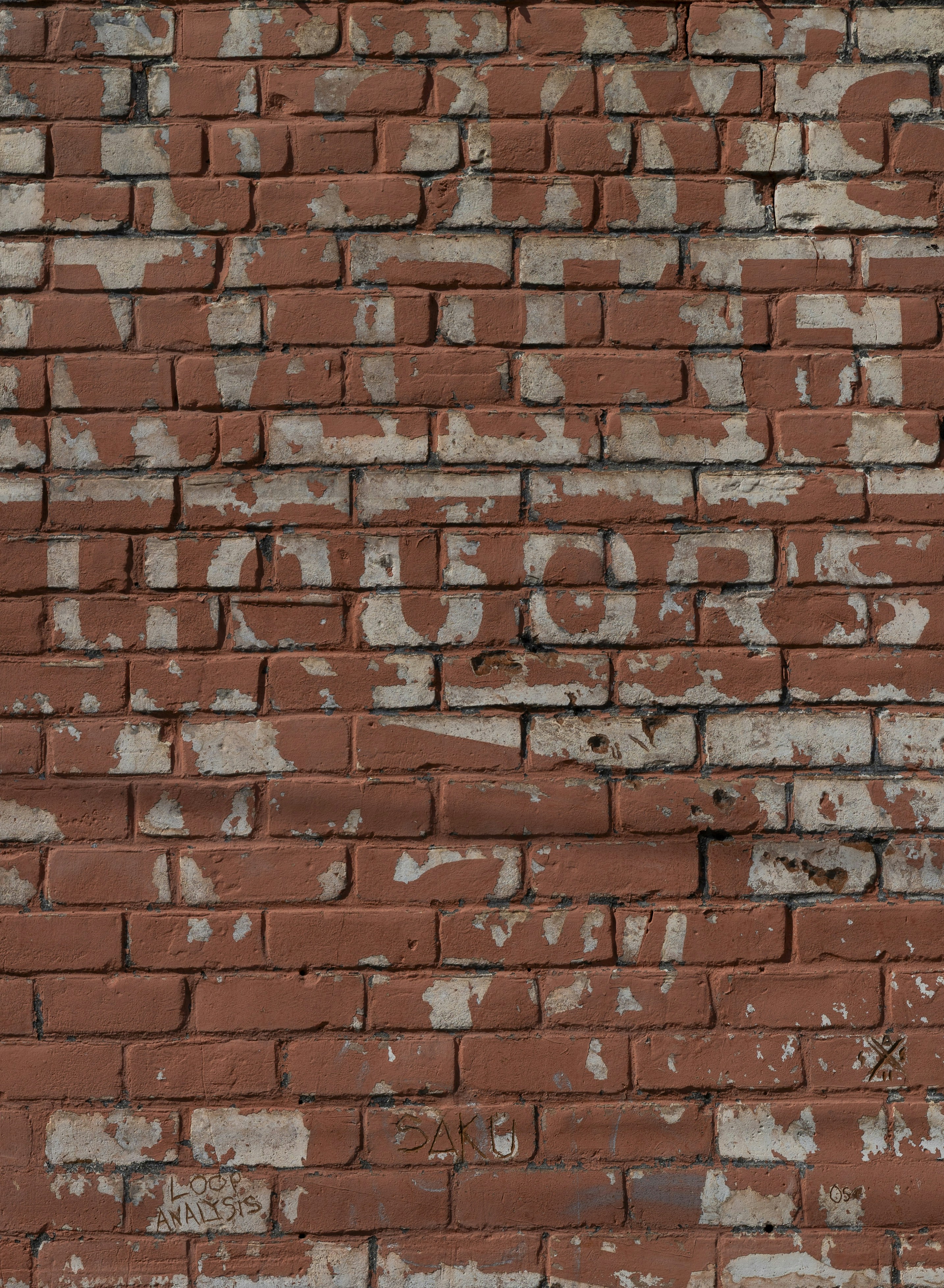 Pared de ladrillo con pintura descascarillada.
