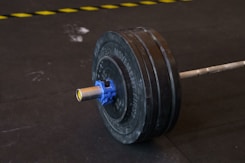 A barbell rests on the ground, ready for use.