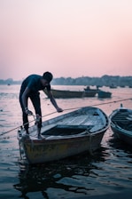 A man ties up a boat at dusk.