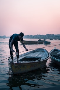 A man ties up a boat at dusk.