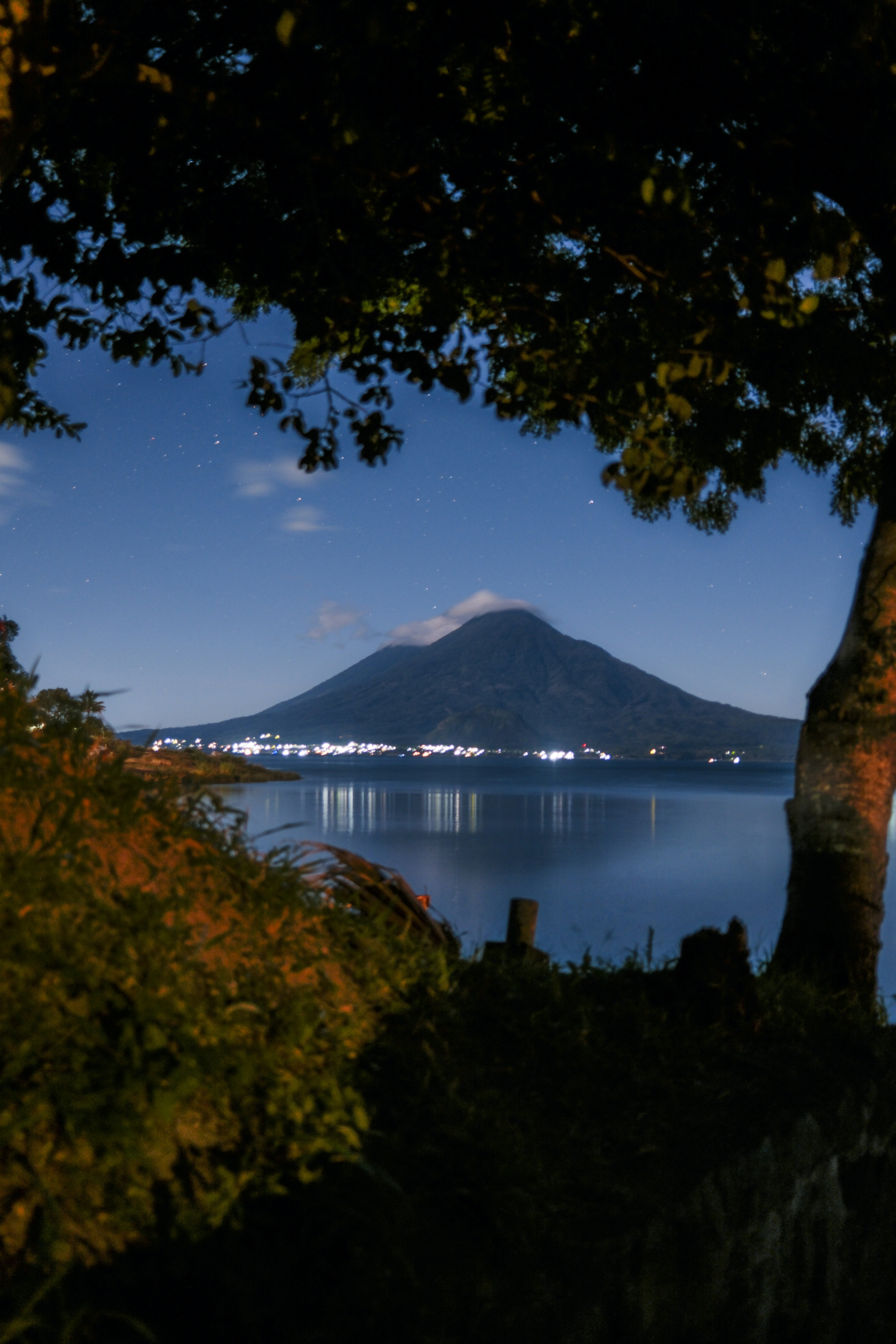 Mountain and water under a starry night sky.