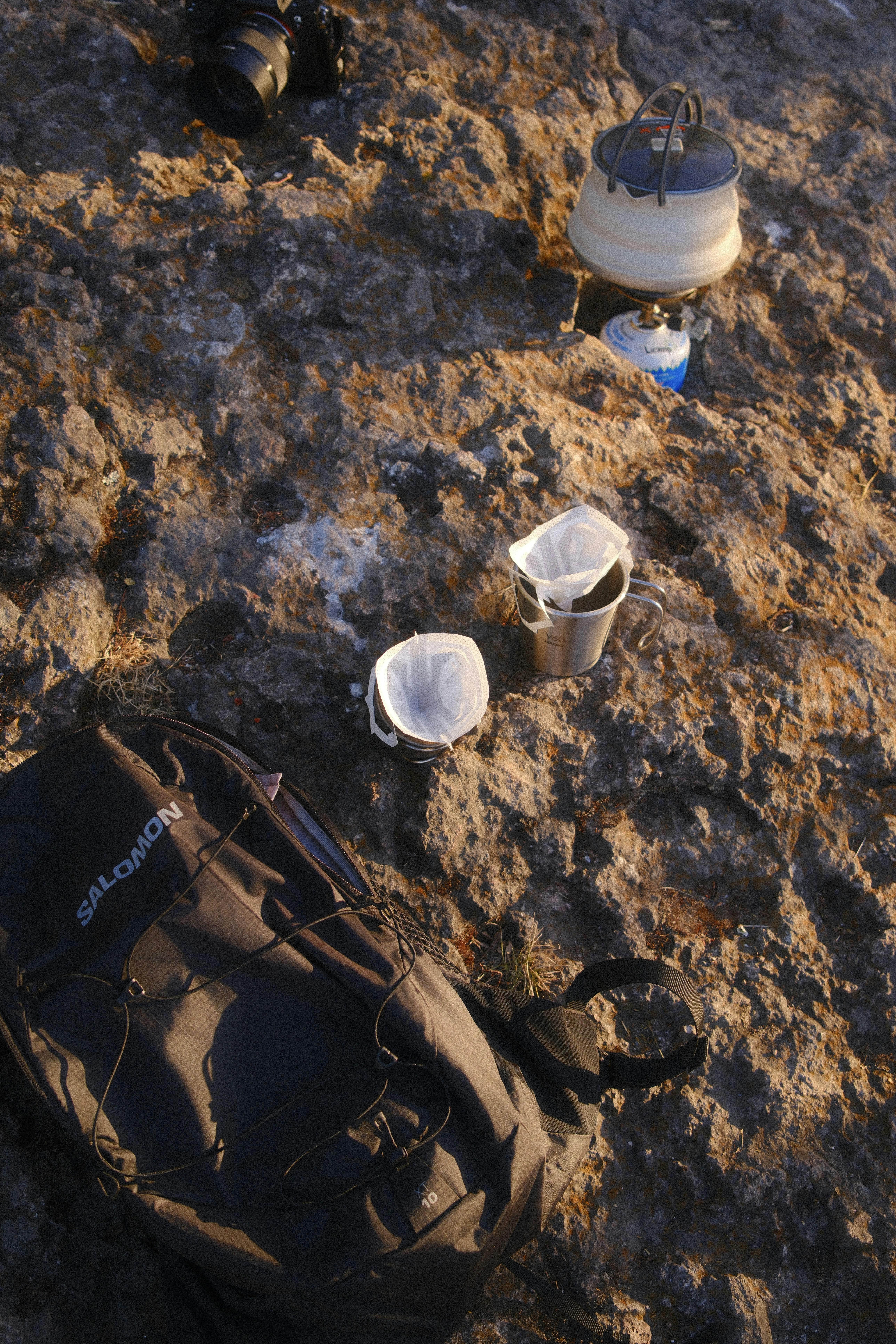 Coffee brewing equipment on a rocky surface.
