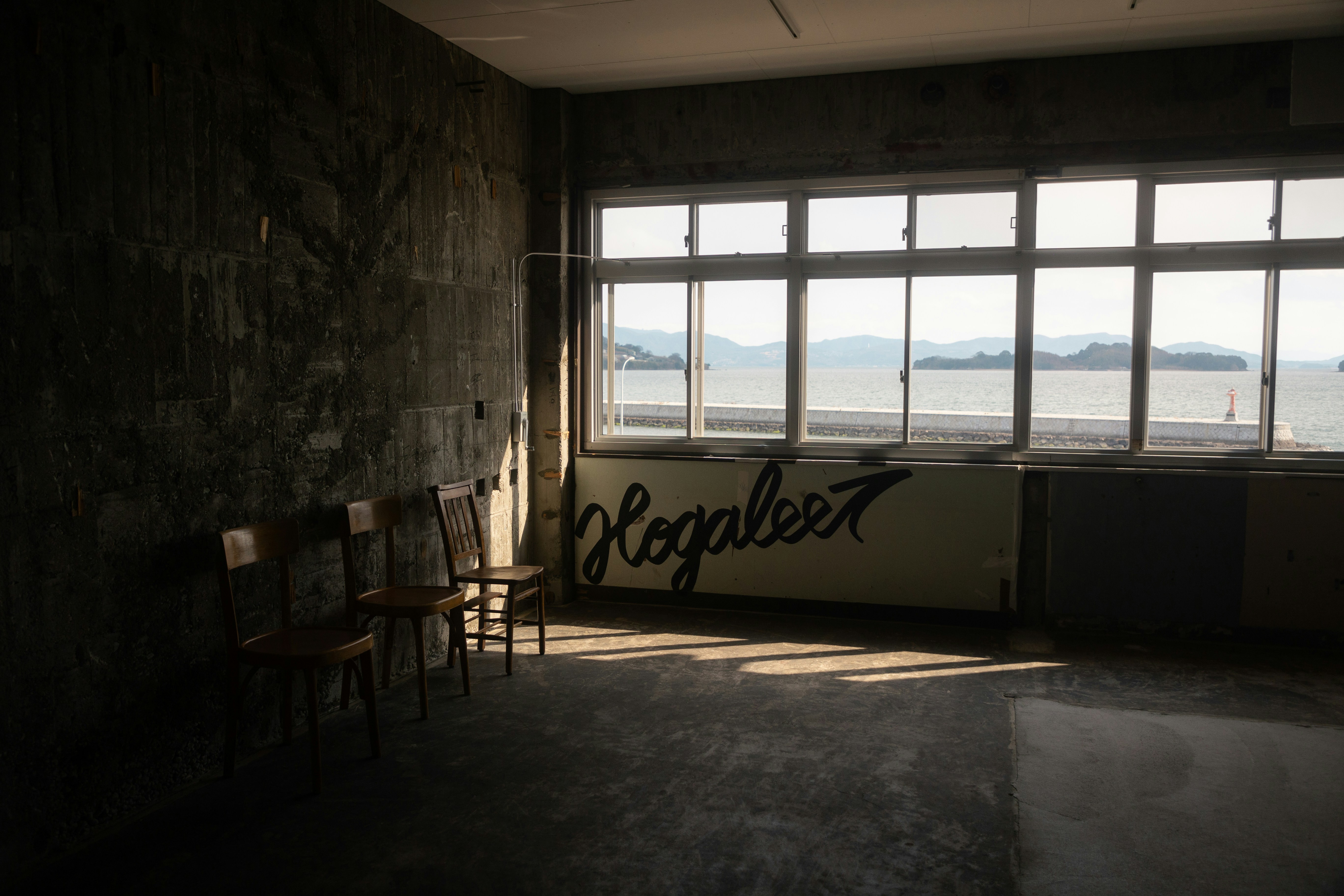Empty room with chairs, a window and sunlight.