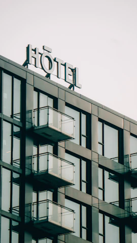Modern hotel exterior with balconies and a sign.