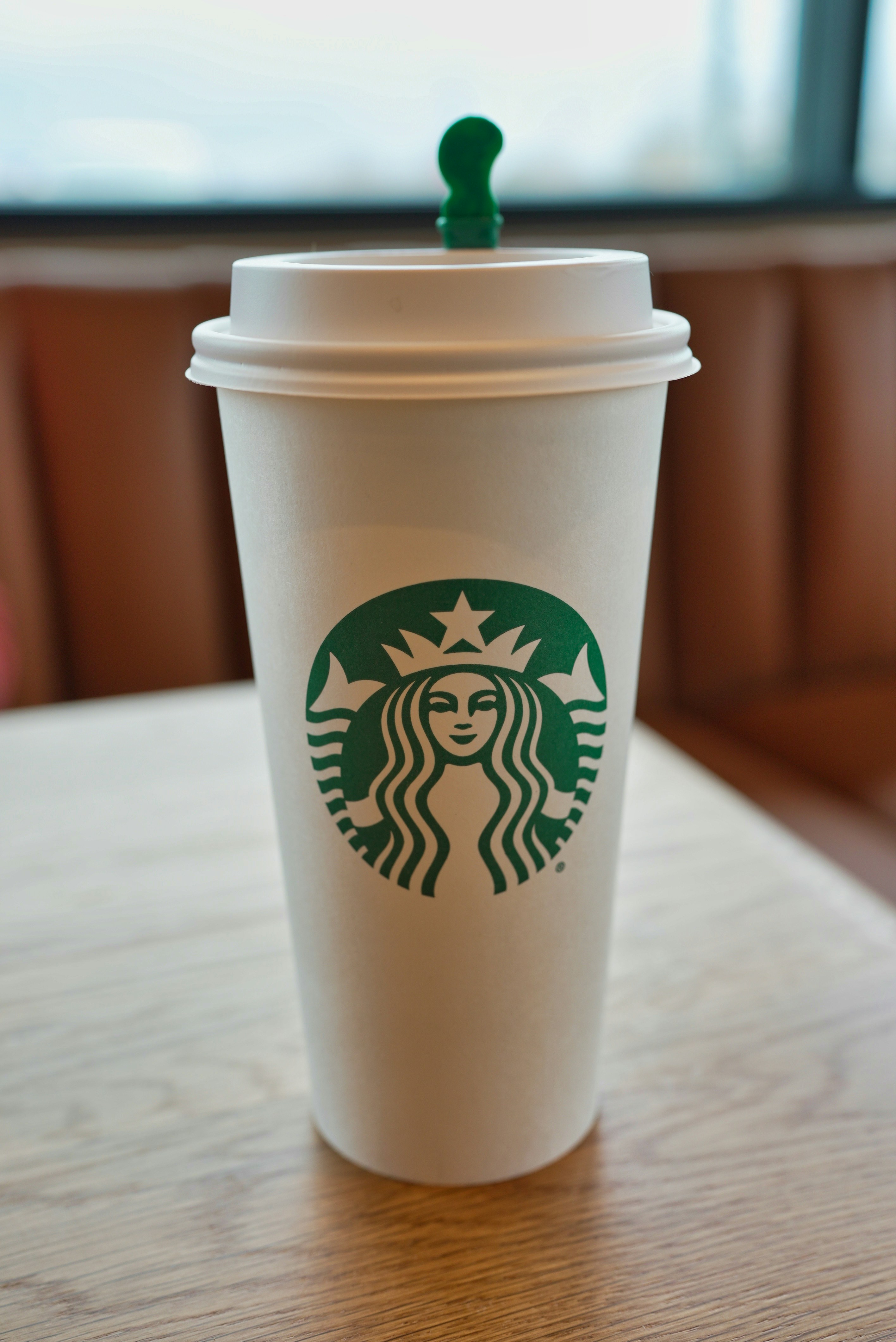 A starbucks cup sits on a table.