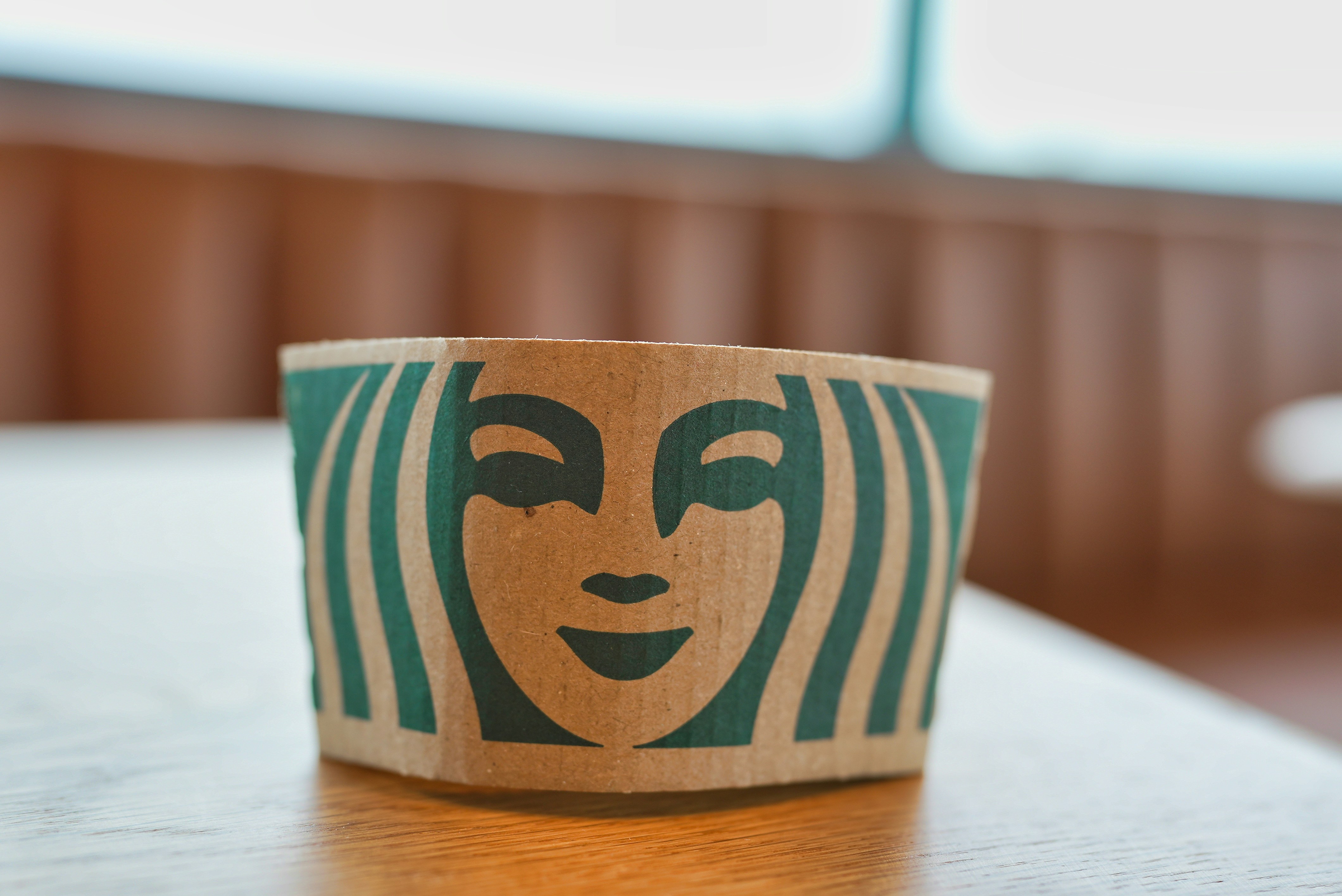 Un manchon de tasse Starbucks est posé sur une table.
