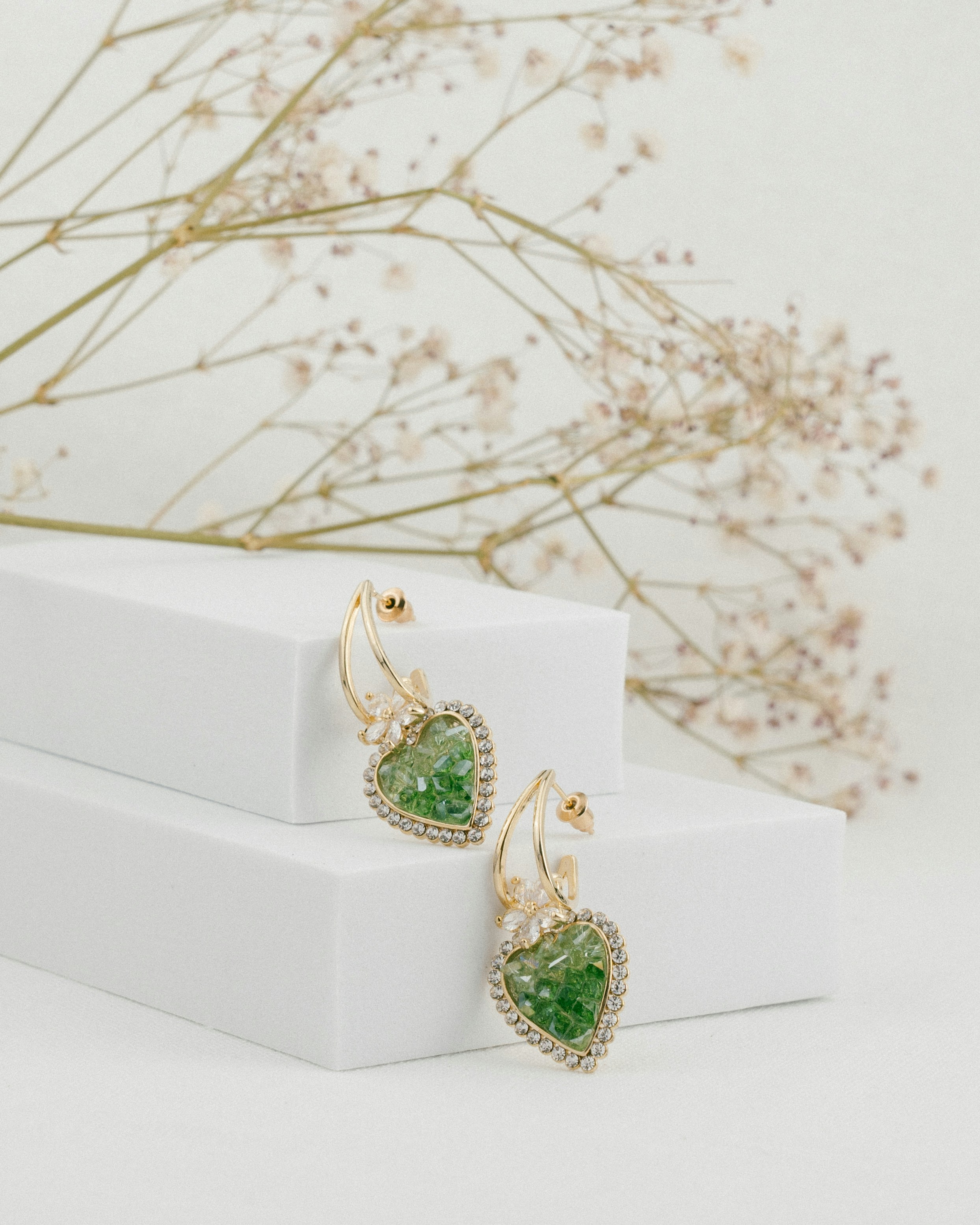 Elegant earrings with green stones and gold trim.