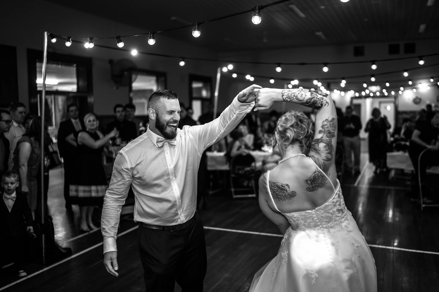 Bride and groom dancing joyfully at their wedding reception with the celebration and movement visible in the photograph