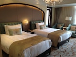 A luxurious hotel room with two beds.