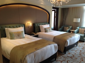 A luxurious hotel room with two beds.