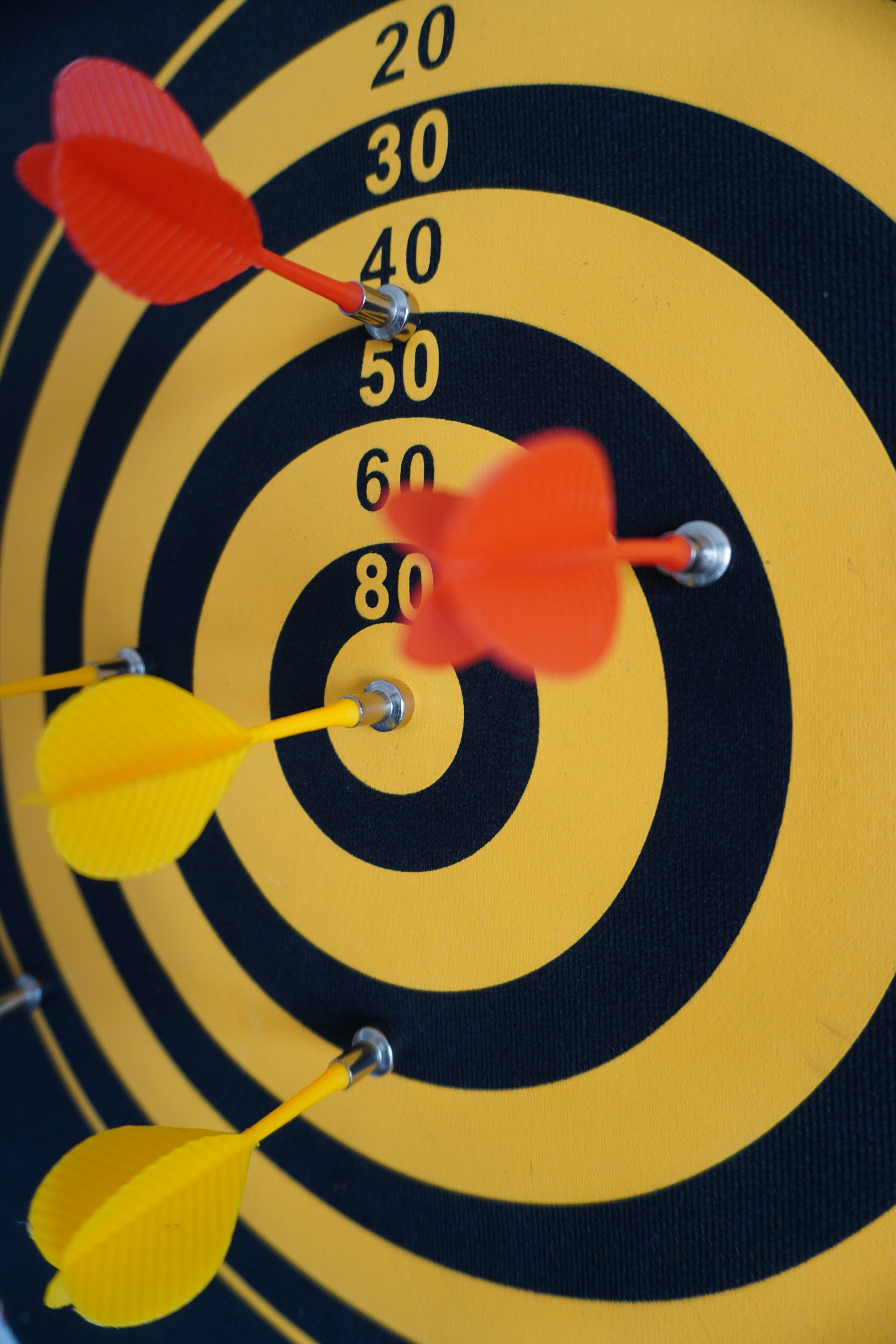 Darts are stuck in the target board.