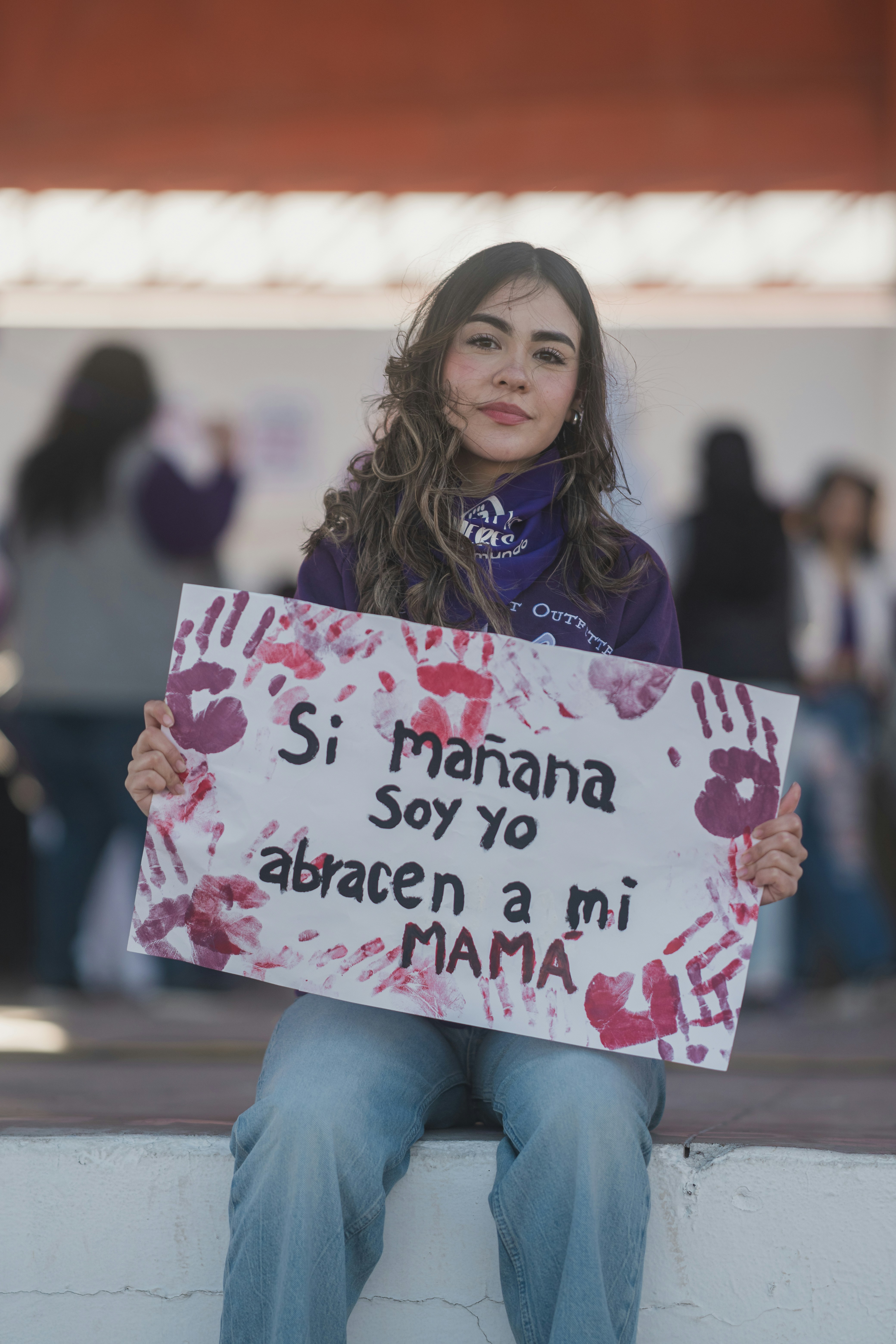 Woman holds a protest sign with a message.