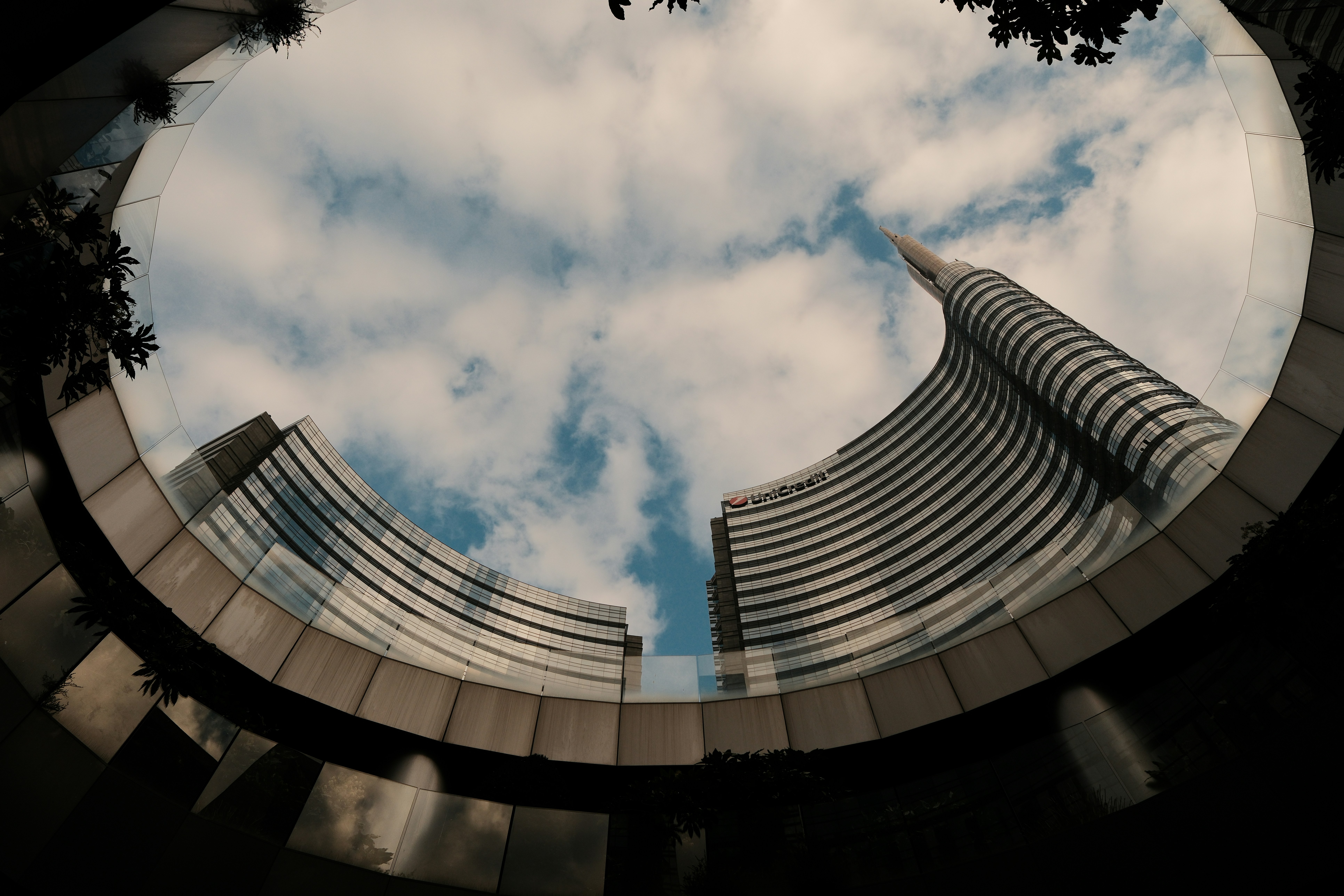 Skyscraper curves up into a beautiful, cloudy sky.