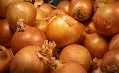 A pile of fresh, brown onions.
