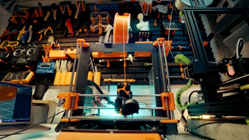 A 3D printer is in action in a workshop.