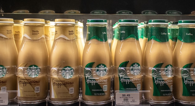 Starbucks frappuccinos chilled on a store shelf.