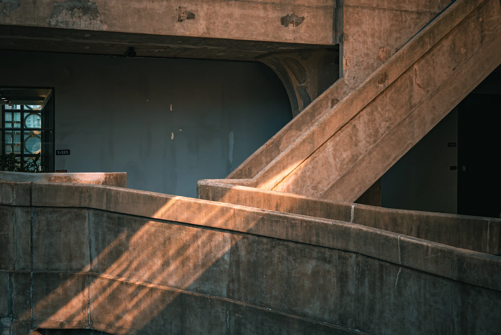 Escalier en béton brut, la lumière rasante dessine chaque marche