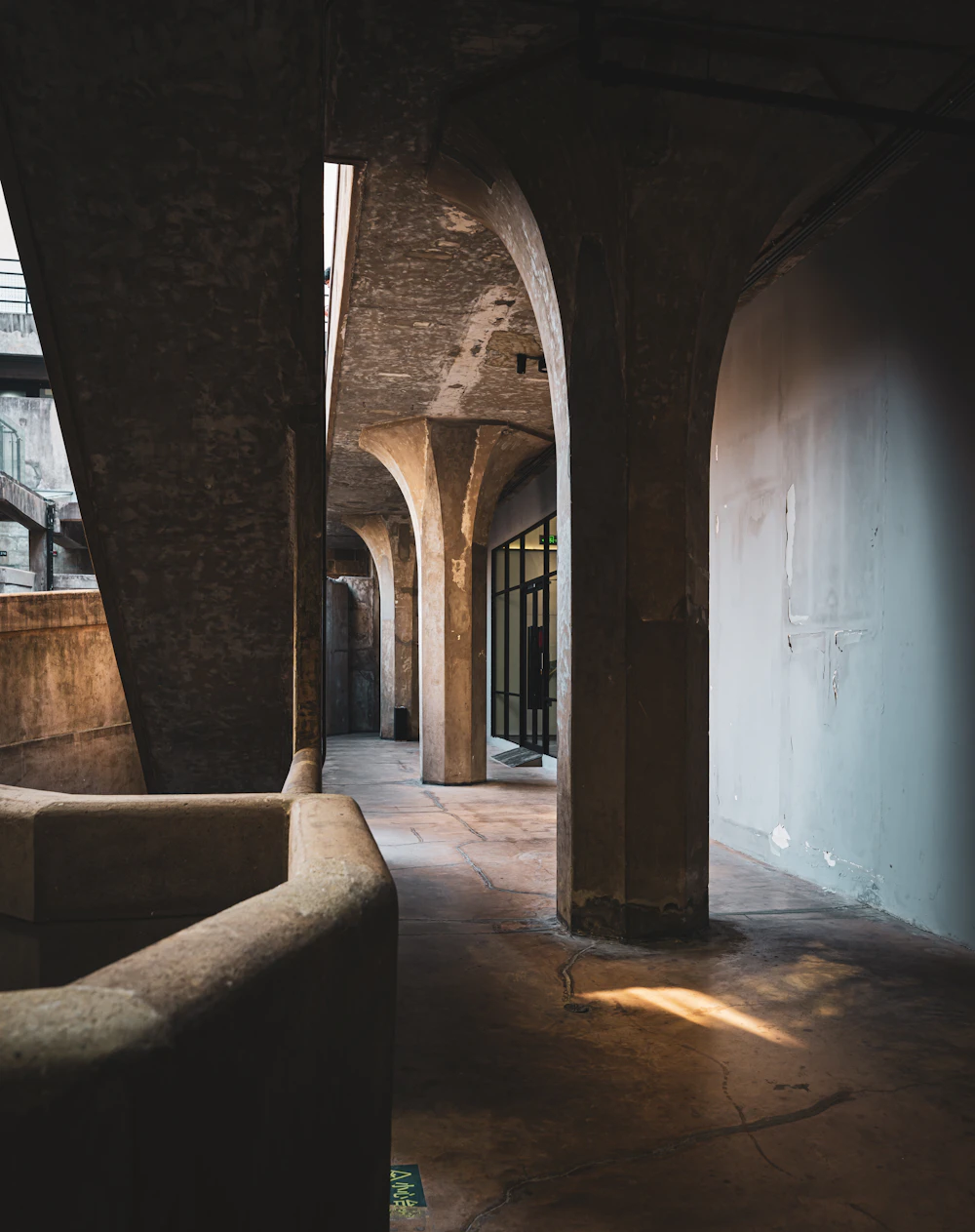 Arched concrete corridor lit by daylight