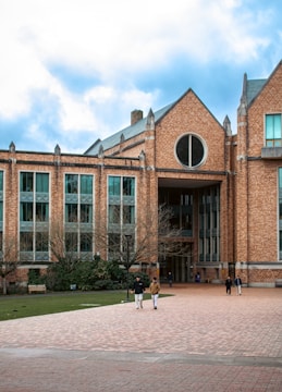 Brick building on campus with people walking.