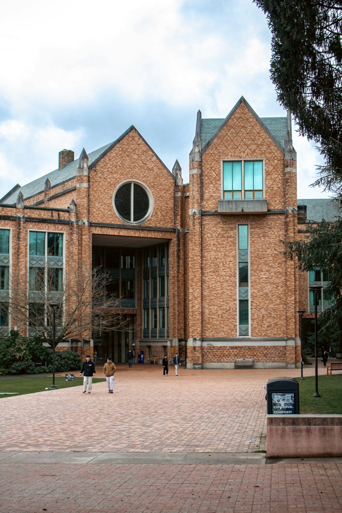 Brick university building with students on the plaza