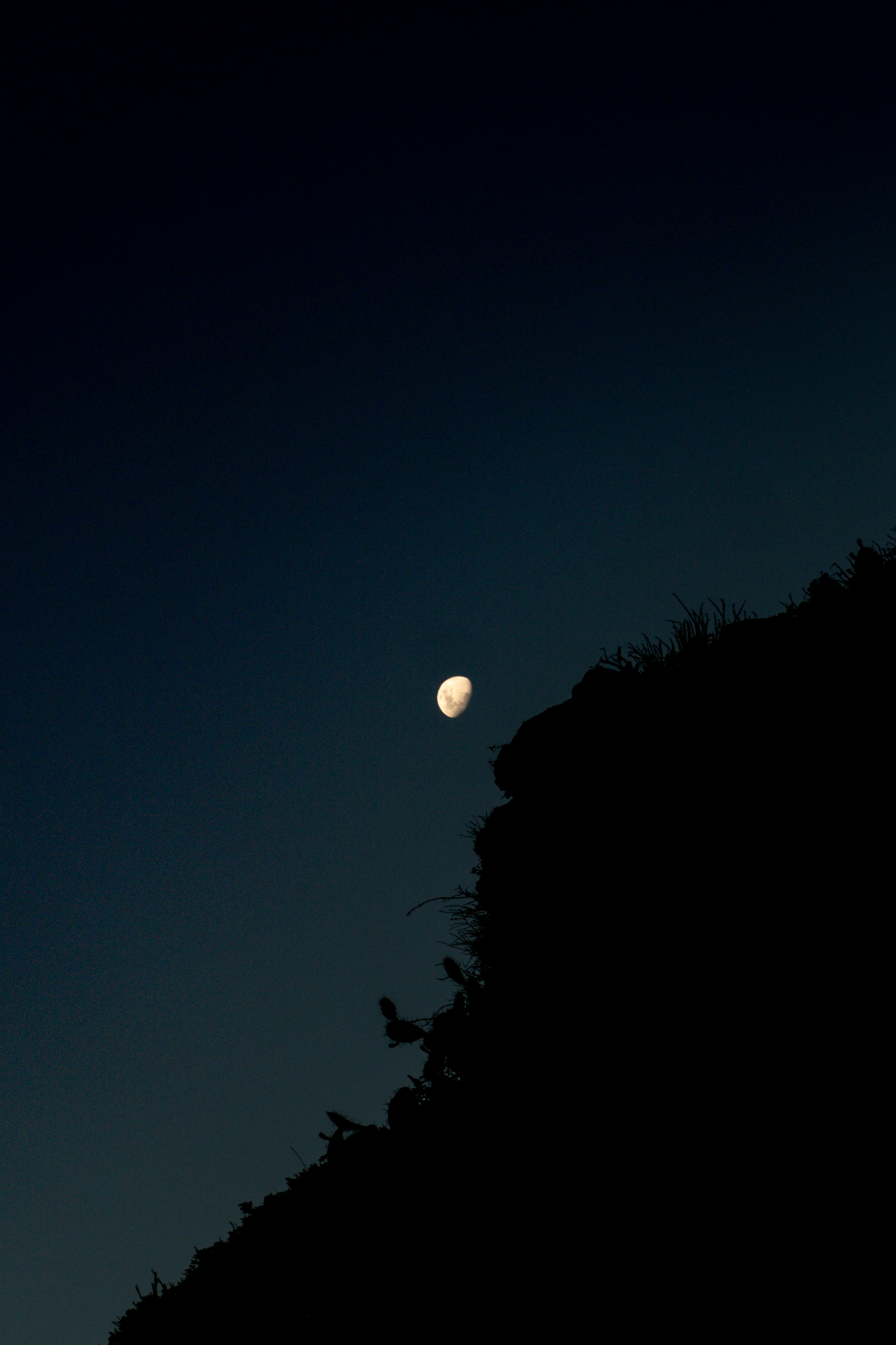 The moon shines over a dark cliffside. photo – Free Wallpaper Image on  Unsplash, image size:3000x4501