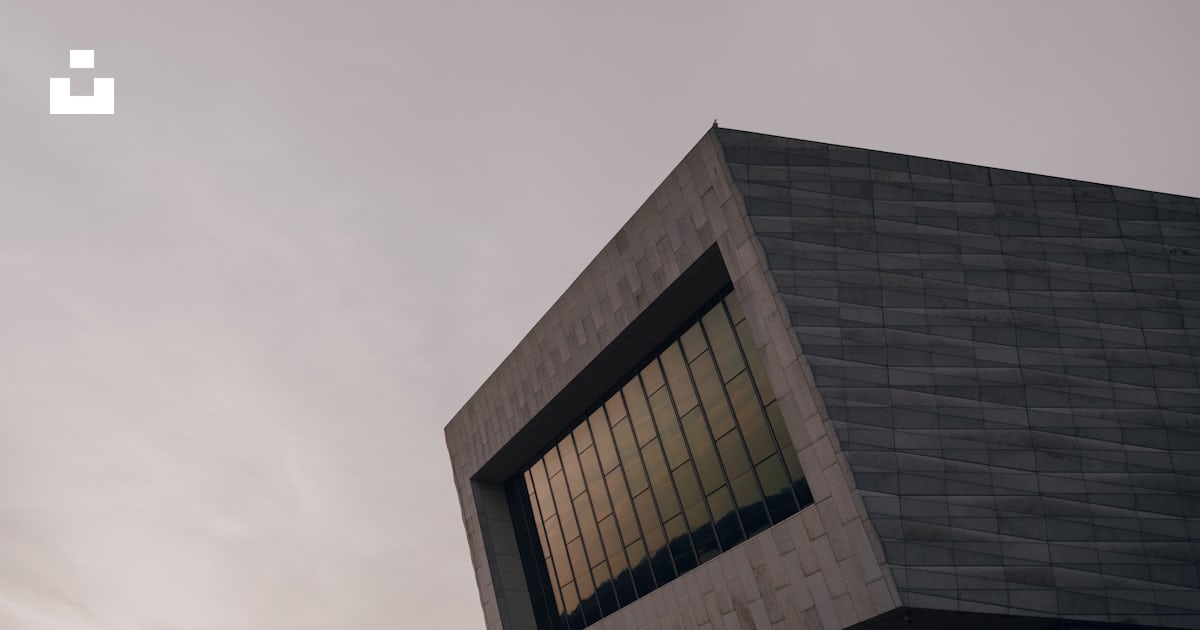 A modern, angular building with a large window. photo – Free Building ...