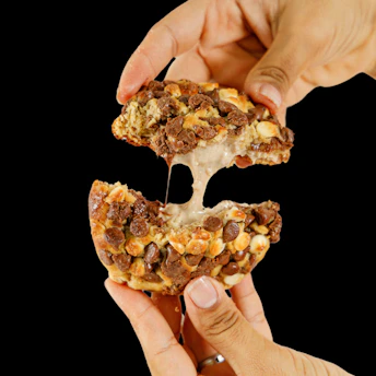 A cookie is being broken, showing gooey filling.