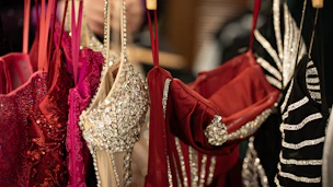 Beautiful, sparkly dresses hanging in a closet.