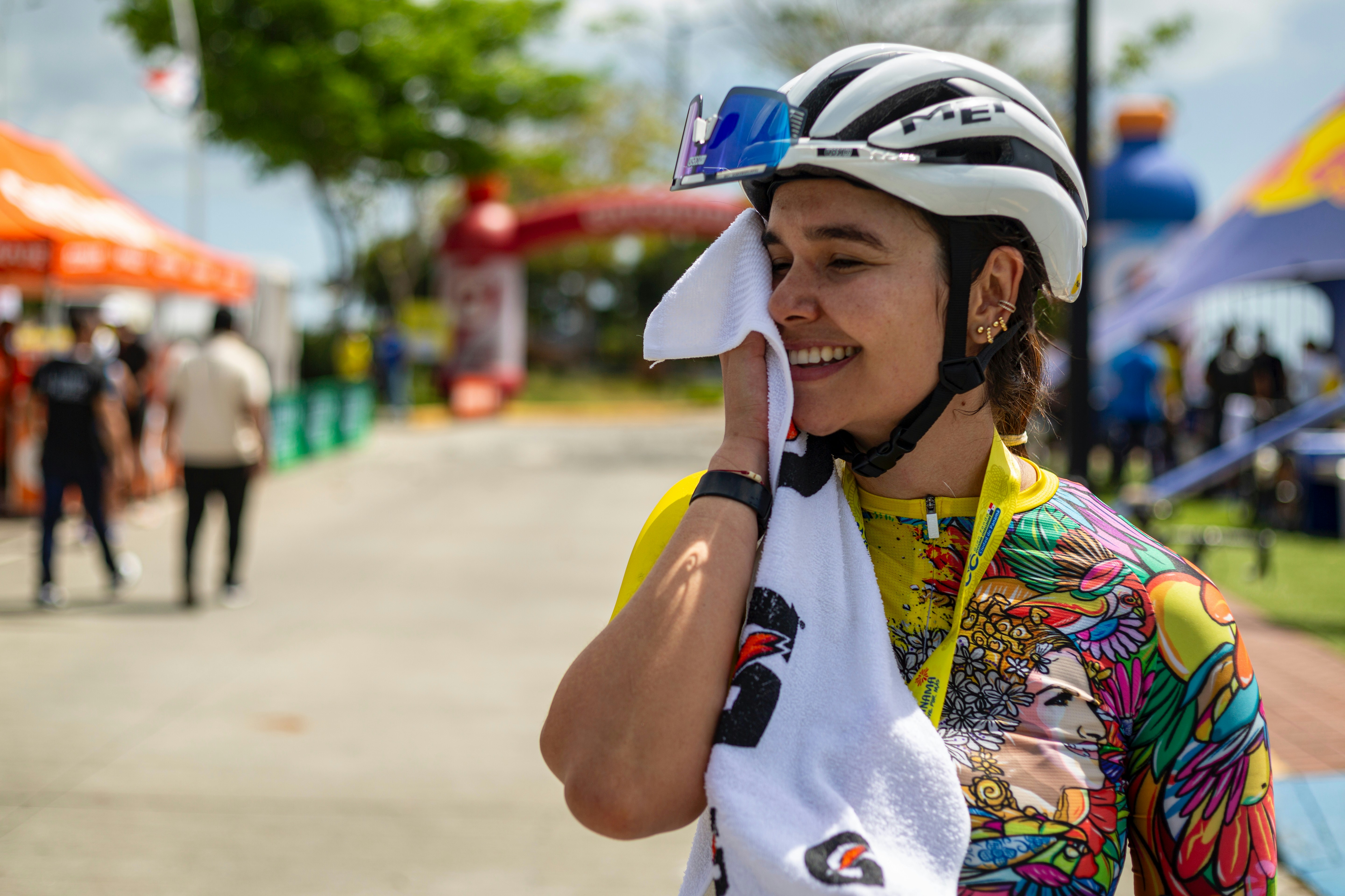 Cyclist wipes sweat off face after finishing race.