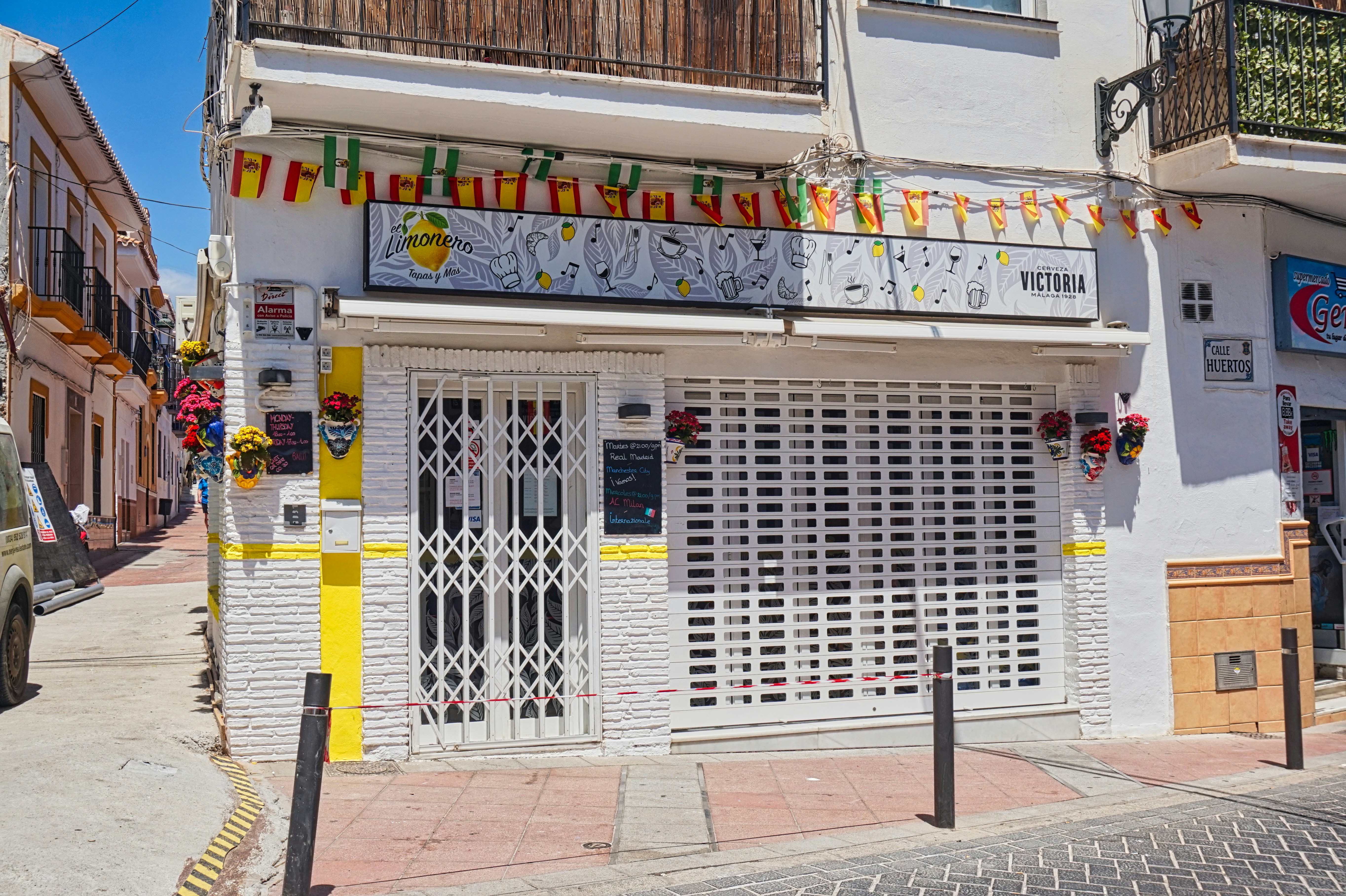 A storefront with decorative flags is shown.