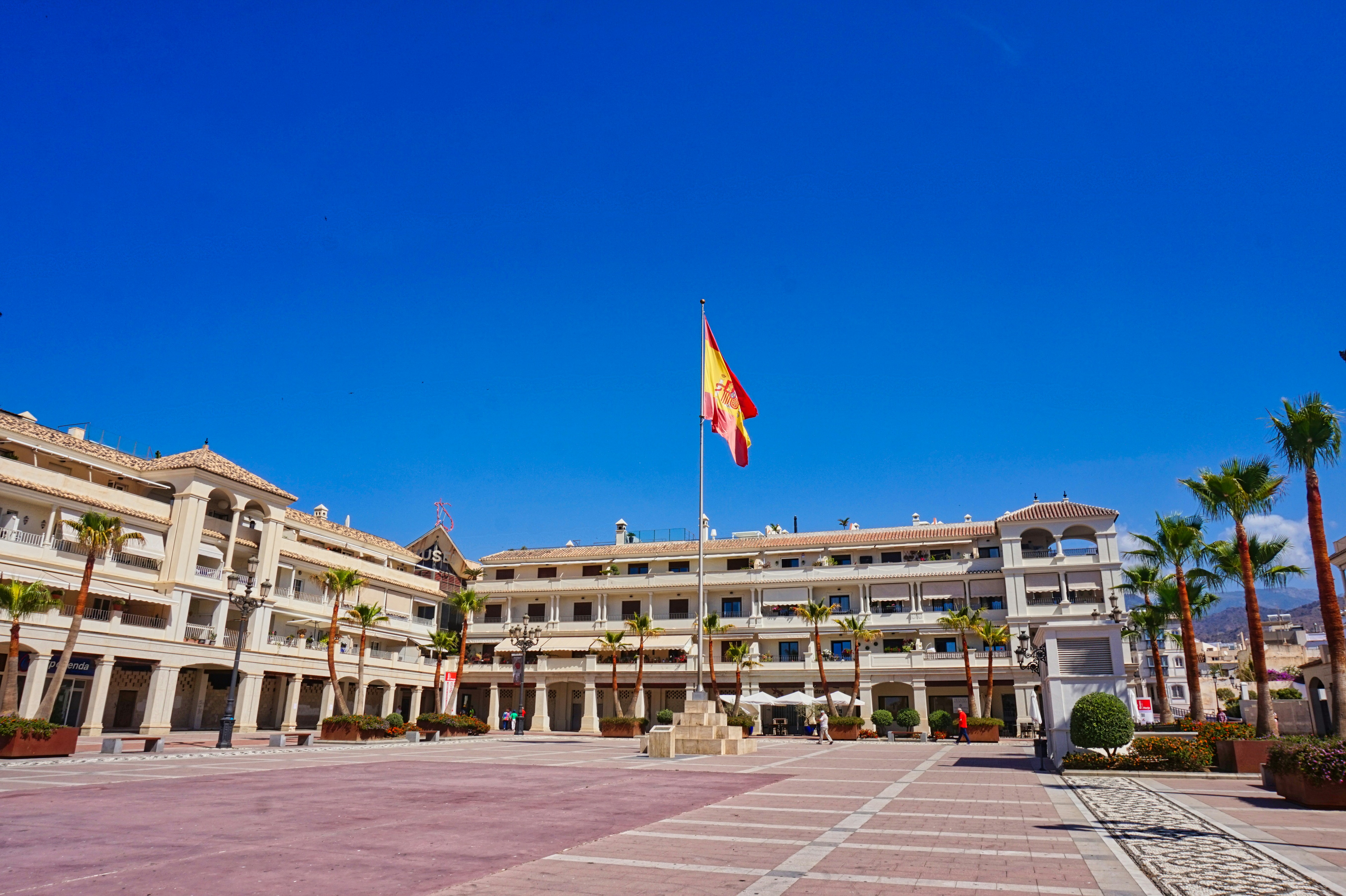 Eine spanische Flagge weht über einem Platz und Gebäuden.