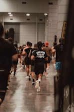 Runners sprint in a large indoor race.