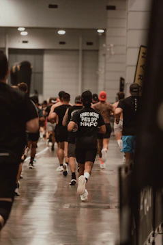 Runners sprint in a large indoor race.