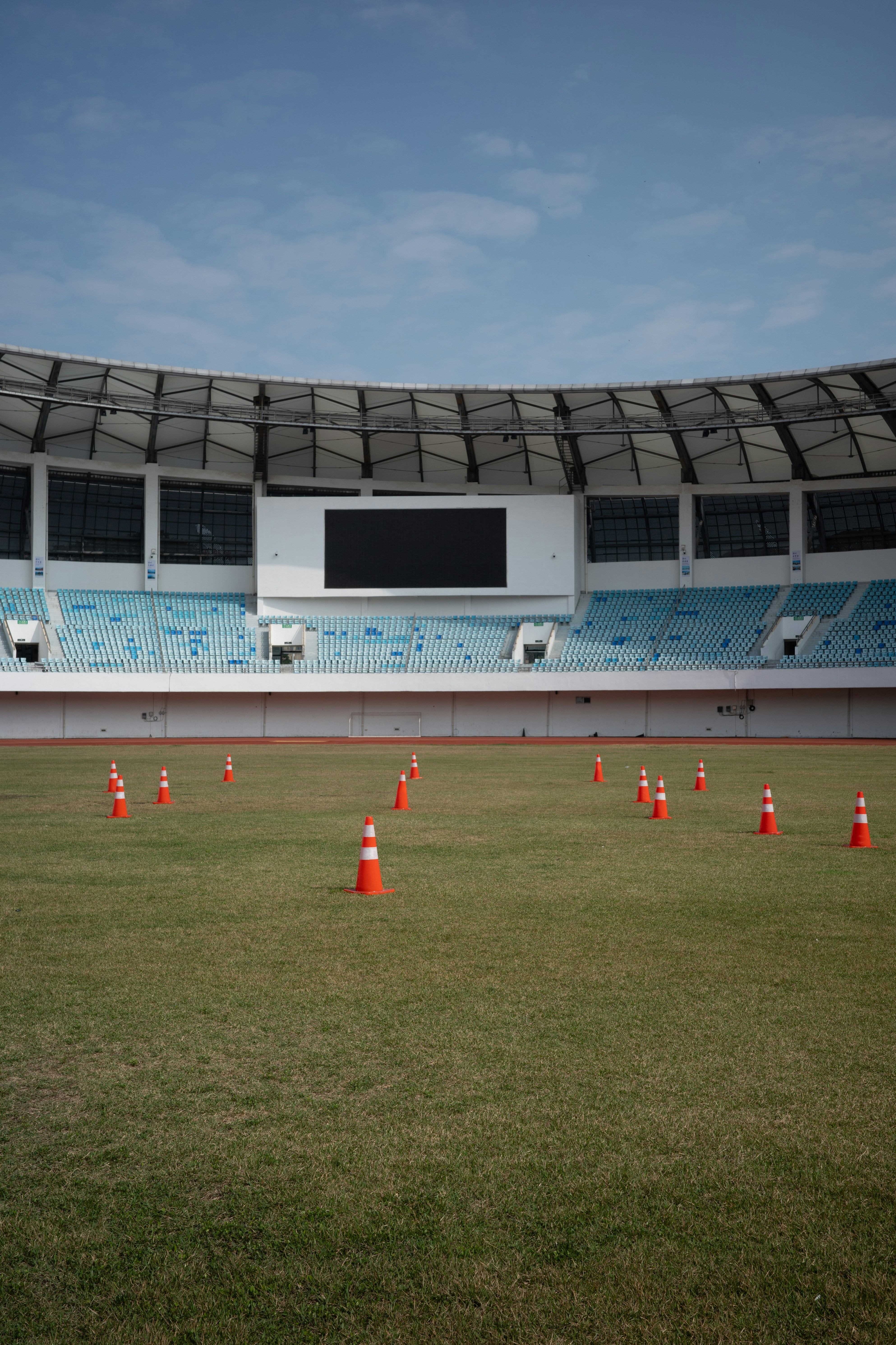 Campo de estadio vacío con conos de tráfico.