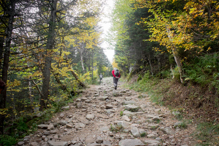 단풍이 물든 바위길을 오르는 등산객. 사진=Unsplash