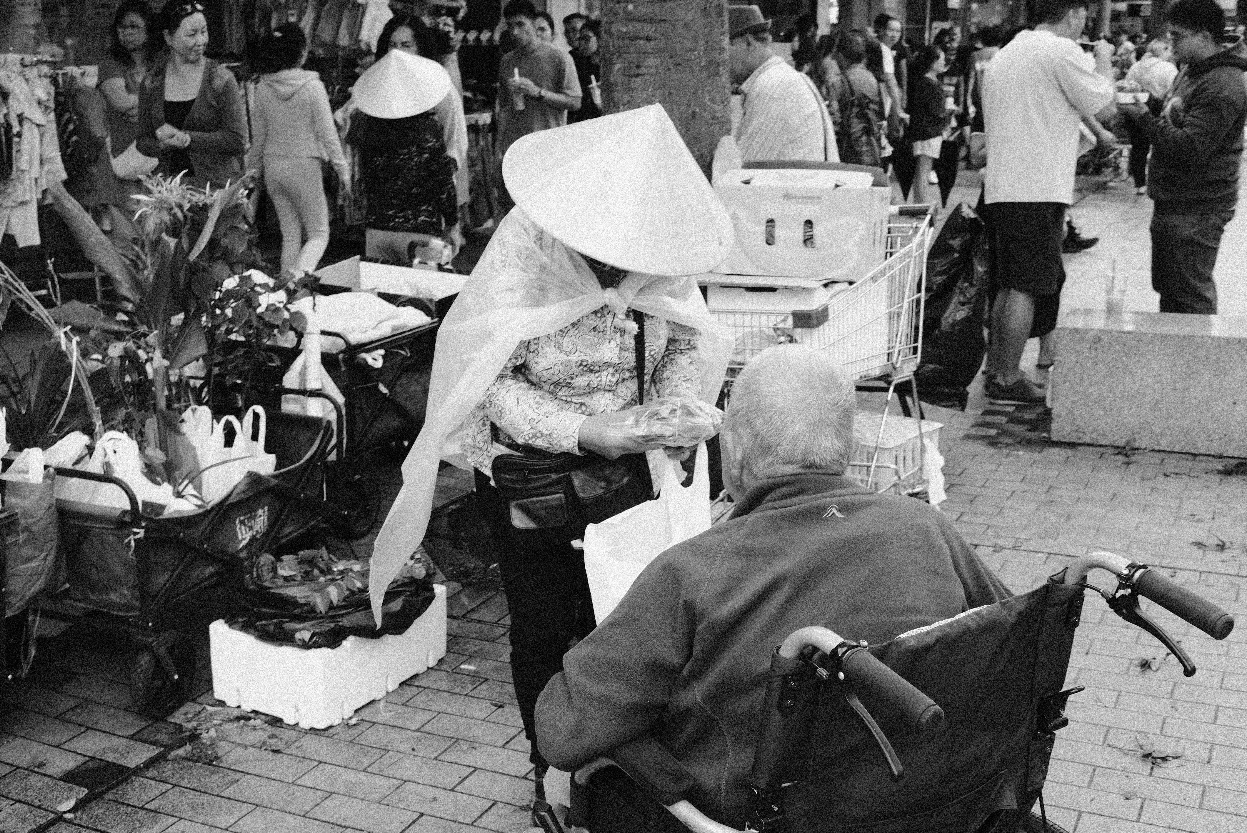 Una mujer ayuda a una persona mayor en silla de ruedas.