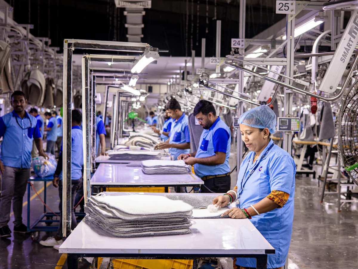 A bright, orderly factory floor with workers in uniform at their stations