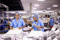 Workers sort and package textiles in a factory.