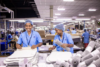 Workers sort and package textiles in a factory.