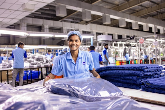Factory worker smiles while working at the factory.
