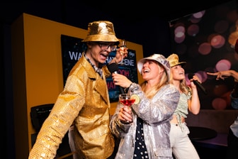 People are partying and singing karaoke with microphones.