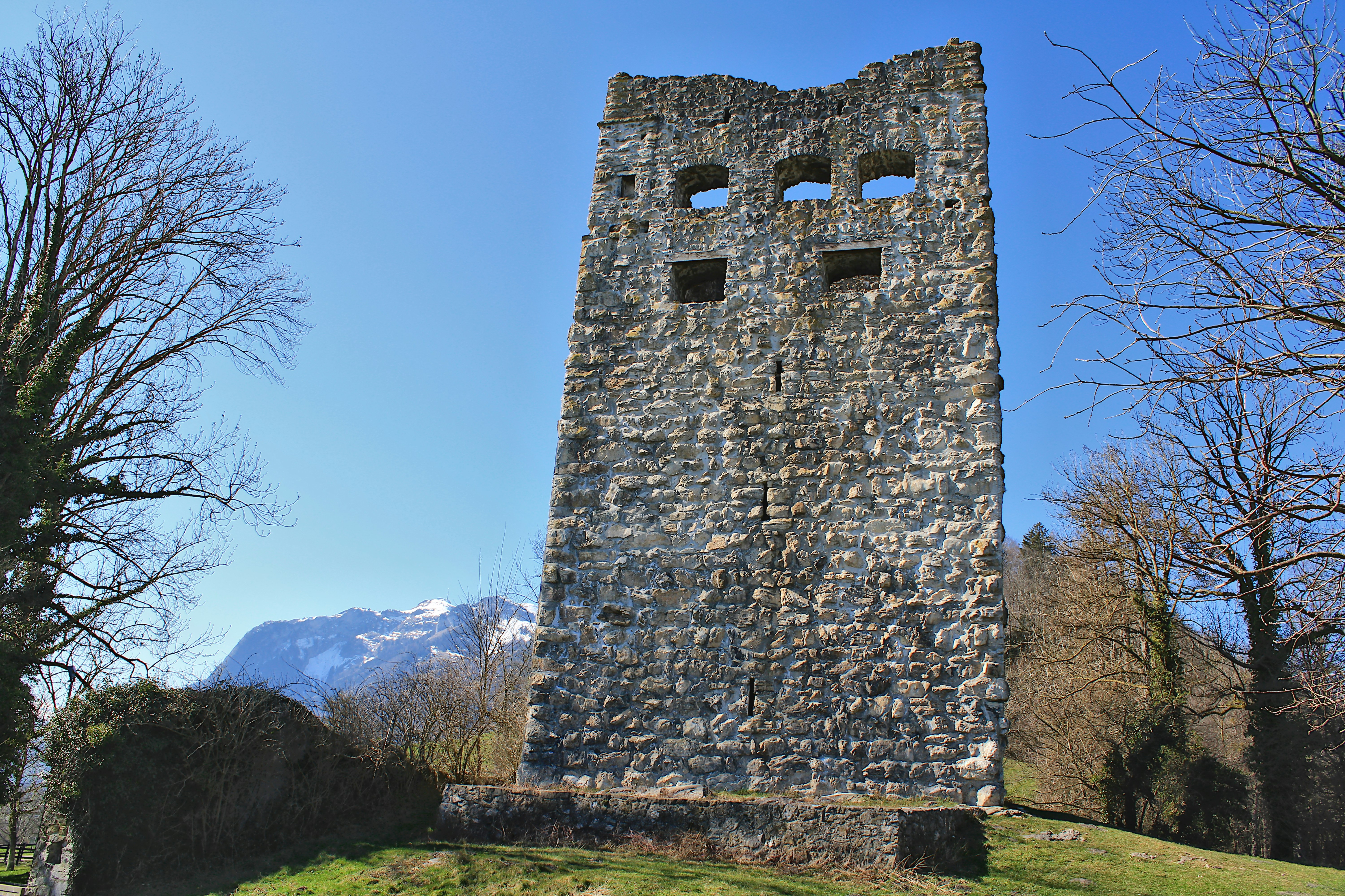 Old stone tower stands tall under blue skies.