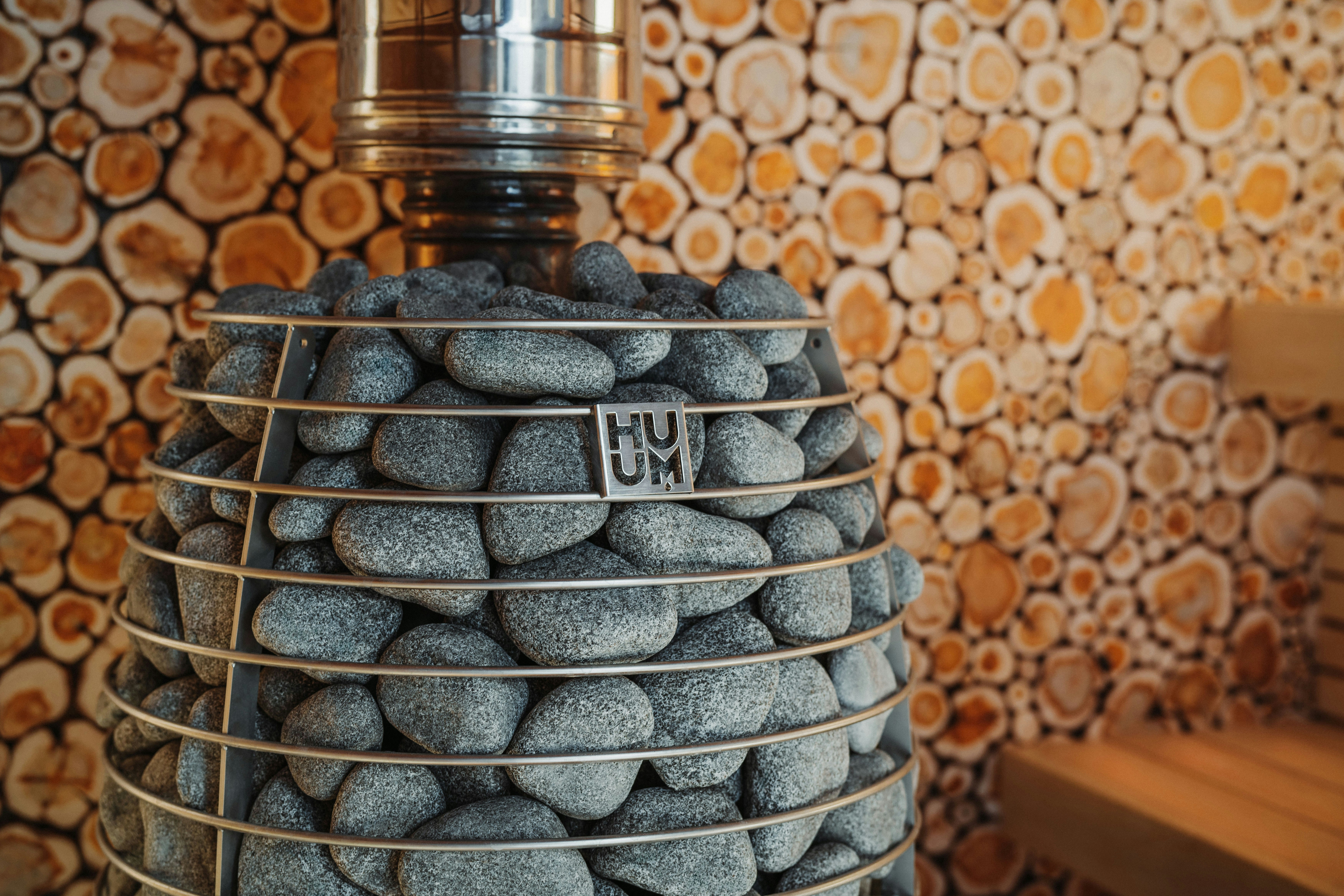 Sauna heater with a wooden wall in the background.