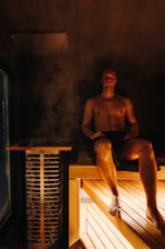 A man is relaxing in a steamy sauna.