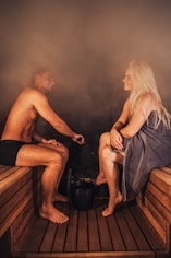 A man and woman relaxing in a sauna.